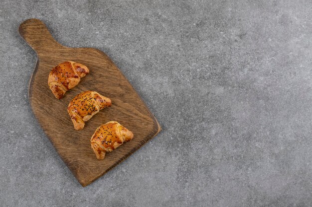 Top view of fresh homemade cookies on wooden board .