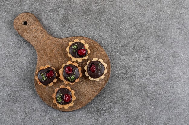 Free photo top view of fresh homemade delicious cookies on wooden cutting board.