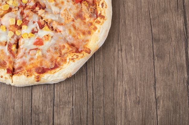 Top view of fresh hot mozzarella pizza on wooden table. 