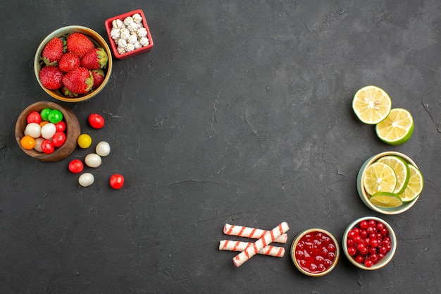 Free photo top view fresh lemon slices with candies and fruits