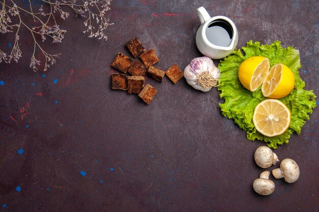 Top view of fresh lemon slices with green salad on dark