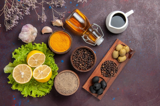 Vista dall'alto di fette di limone fresco con olive e condimenti al buio