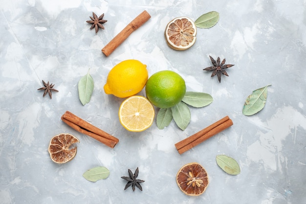 無料写真 トップビュー新鮮なレモンジューシーで酸っぱいシナモンと白い机の熱帯のエキゾチックなフルーツ柑橘類