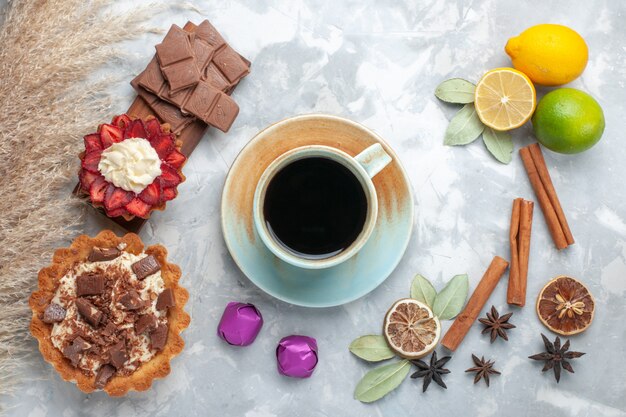 Top view fresh lemons juicy and sour with cinnamon chocolate tea and cakes on white desk tropical exotic fruit citrus