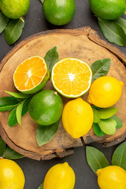 Бесплатное фото Вид сверху свежие лимоны на темном столе, лайм, кислые фрукты, цитрусовые