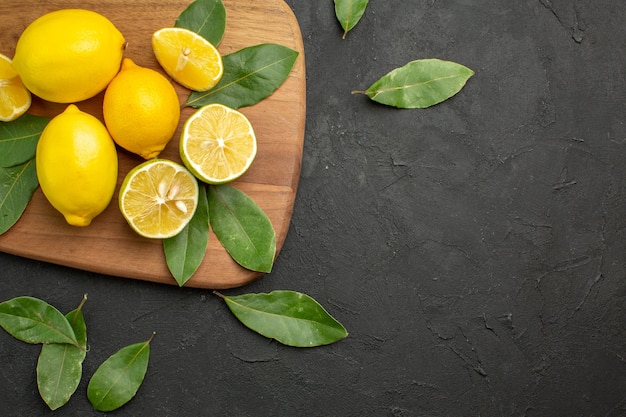暗いテーブルの柑橘系の果物の上面図新鮮なレモン酸っぱい果物