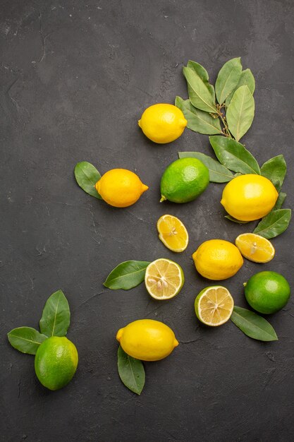 Top view fresh lemons sour fruits on dark table, citrus lime fruit