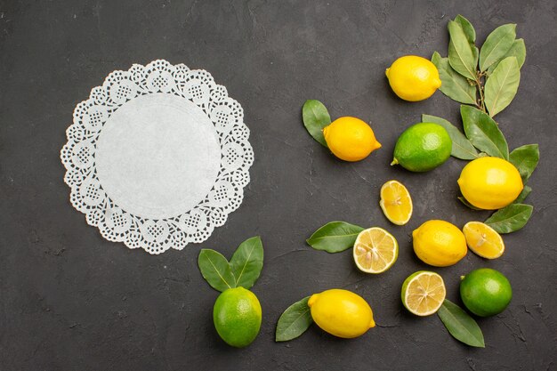 Top view fresh lemons sour fruits on a dark table lime citrus fruit