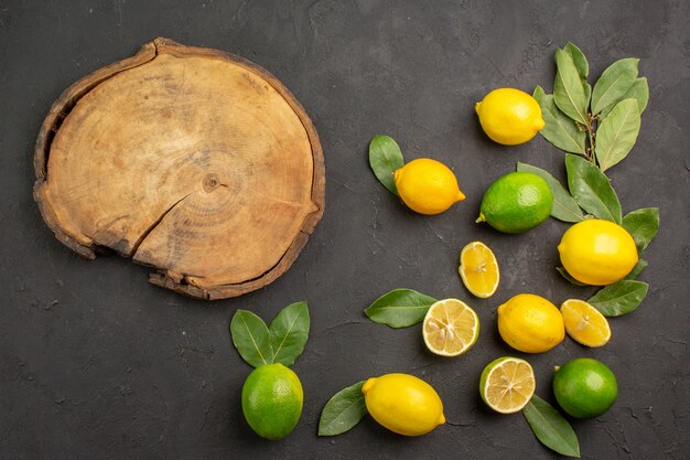 Top view fresh lemons sour fruits on dark table, lime citrus fruit