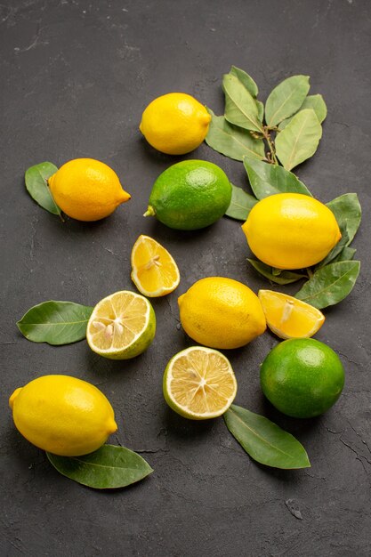 Top view fresh lemons sour fruits on dark table lime citrus fruits