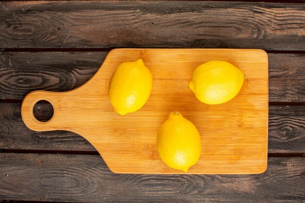 A top view fresh lemons sour ripe mellow citrus juicy tropical vitamine yellow on the brown rustic desk