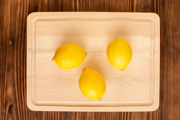 A top view fresh lemons sour ripe mellow juicy citrus vitamine yellow on the brown rustic desk