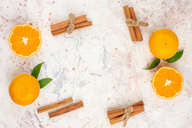 Free photo top view fresh mandarines cinnamon sticks on bright isolated surface free space