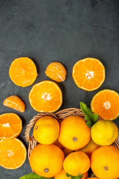 Top view fresh mandarines in wicker basket on dark background