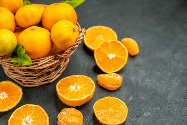 Top view fresh mandarines in wicker basket on dark background