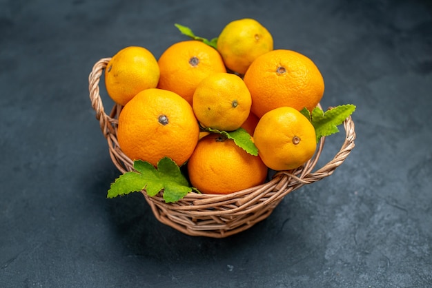 Top view fresh mandarines in wicker basket on dark background