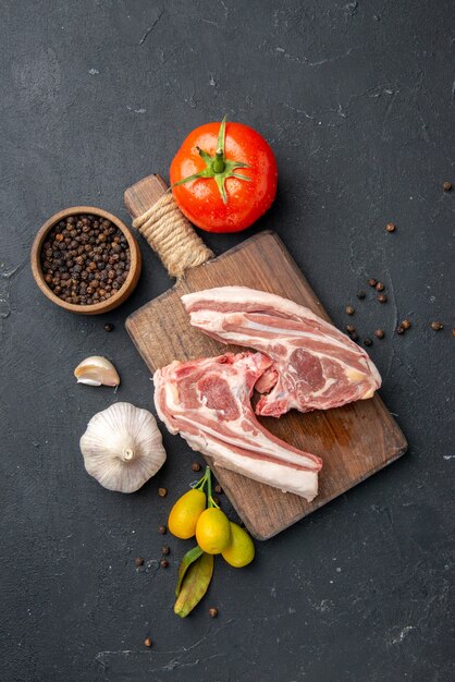 Foto gratuita vista dall'alto costolette di carne fresca carne cruda con condimenti su barbecue scuro piatto di animali pepe cibo da cucina insalata di mucca cibo da pasto