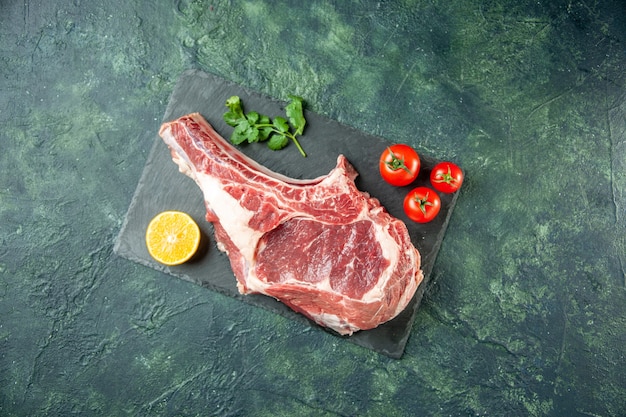 진한 파란색 배경 주방 동물 소 음식 정육점 고기 색상에 빨간 토마토와 상위 뷰 신선한 고기 조각