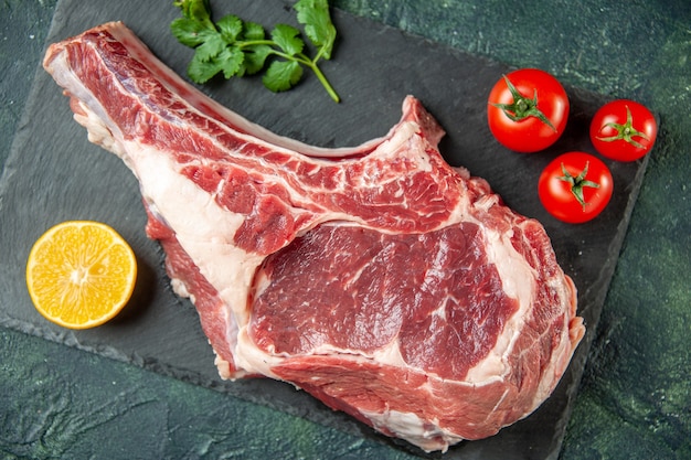 上面図紺色の背景に赤いトマトと新鮮な肉のスライスキッチン動物牛料理肉屋肉鶏肉色