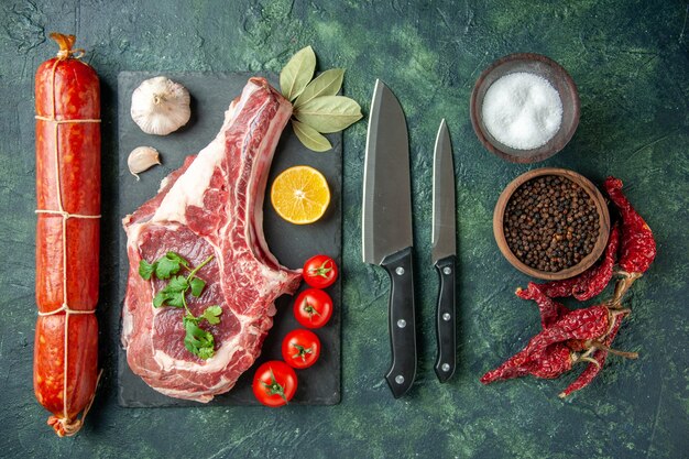 紺色の背景にソーセージと新鮮な肉のスライスを上面図食品肉キッチン動物牛肉屋鶏の色