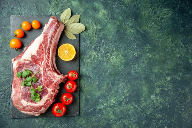 Free photo top view fresh meat slice with tomatoes on dark blue background food meat kitchen animal cow butcher chicken color free space