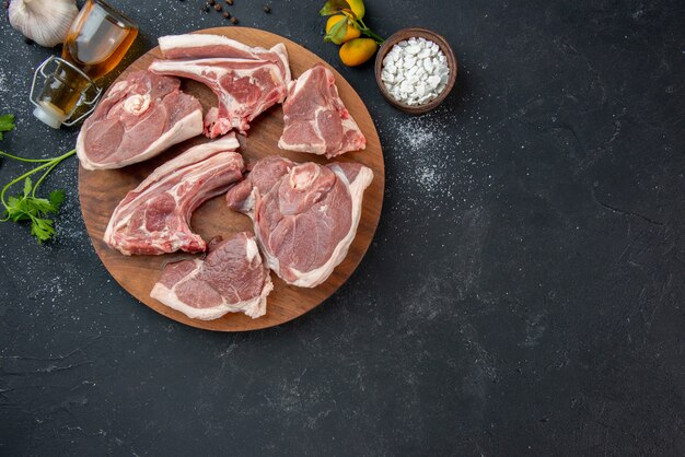 上面図新鮮な肉は暗いバーベキュー皿ペッパーキッチンフード牛料理動物の食事で生肉をスライスします