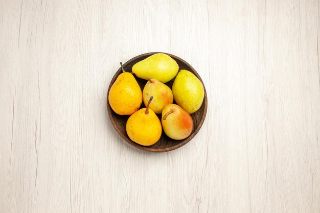 Top view fresh mellow pears sweet fruits inside plate on a white desk fruit yellow fresh ripe sweet