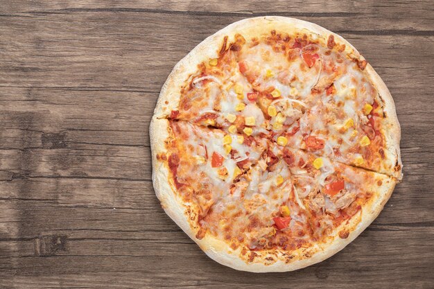 Top view of fresh mozzarella pizza on wooden table. 