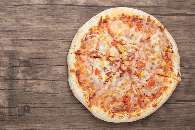 Top view of fresh mozzarella pizza on wooden table. 