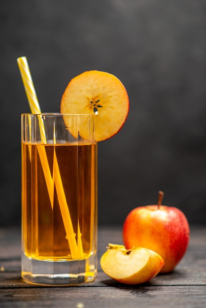 Top view of fresh natural delicious juice in two glasses with red apple limes on black background