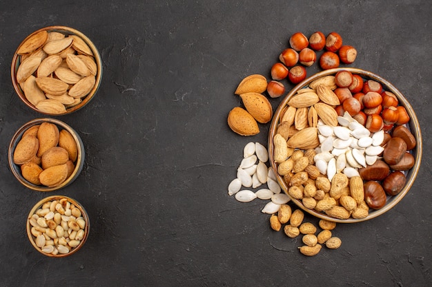 Top view of fresh nuts peanuts and other nuts on a dark surface