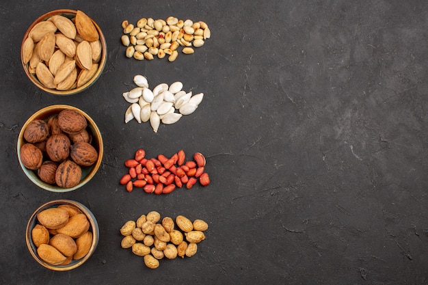 Top view of fresh nuts peanuts and other nuts on dark surface