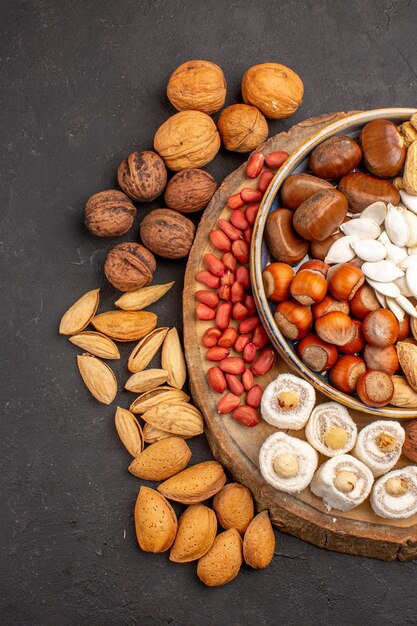 Top view of fresh nuts peanuts and other nuts on dark surface