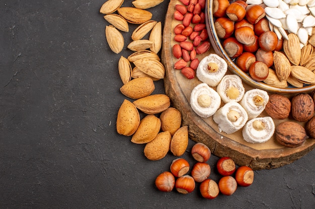 Top view of fresh nuts peanuts and other nuts on dark surface