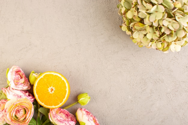 A top view fresh oranges sour ripe sliced and whole mellow citrus tropical vitamine yellow along with dried flowers on the cream desk