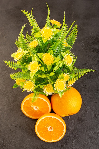トップビューフレッシュオレンジの酸っぱい熟した全体とスライスした植物暗い机の上の黄色い柑橘類のトロピカルビタミンイエロー