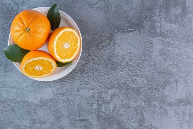 Top view of fresh organic citrus fruit. Organic oranges on plate.