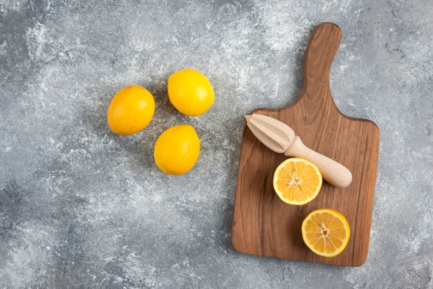 top view of fresh organic lemons on wooden chopping board and on ground.
