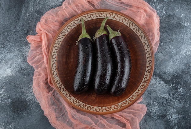 Free photo top view of fresh organic purple eggplant on wooden board