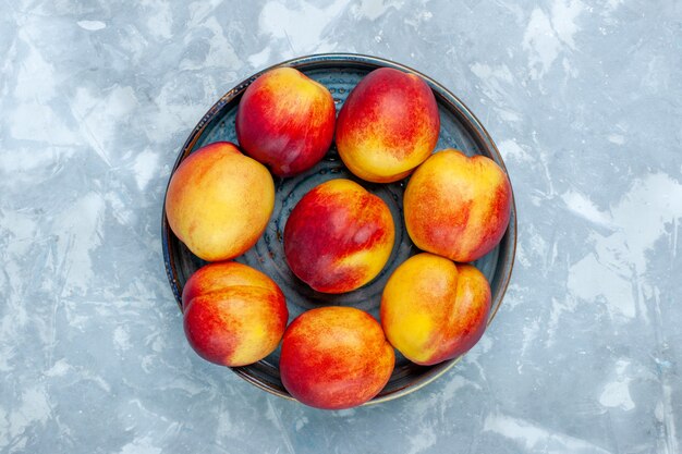 Вид сверху свежие персики вкусные летние фрукты на светло-белом столе