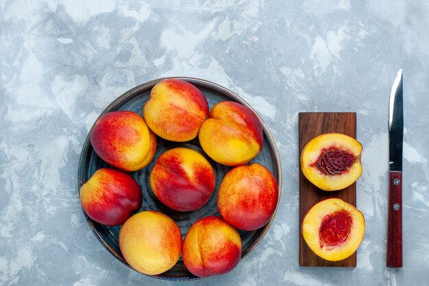 Top view fresh peaches delicious summer fruits on the light white desk