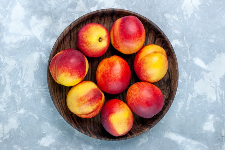 Free Photo top view fresh peaches mellow and tasty fruits inside brown plate on light-white desk