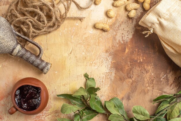 Top view of fresh peanuts with jam on wooden surface