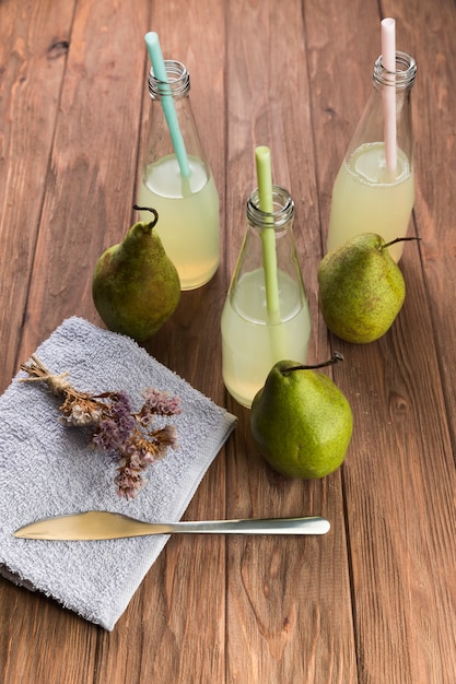 木製のテーブルの上から見る新鮮な梨ジュースのボトル