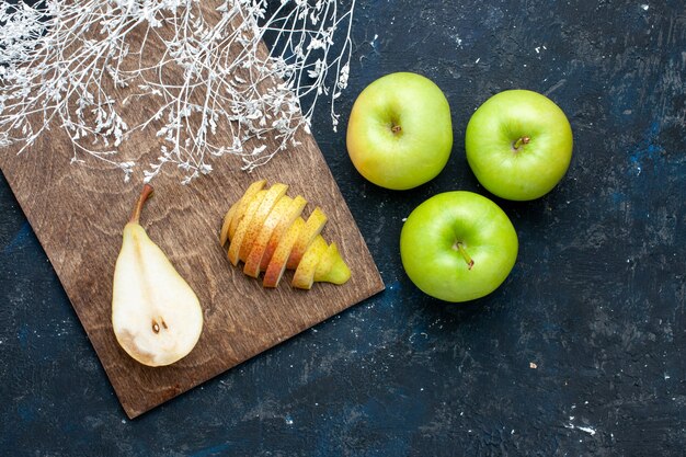 紺色の机の上に青リンゴとスライスした甘い新鮮な梨の上面図、果物の新鮮なまろやかな食品の健康