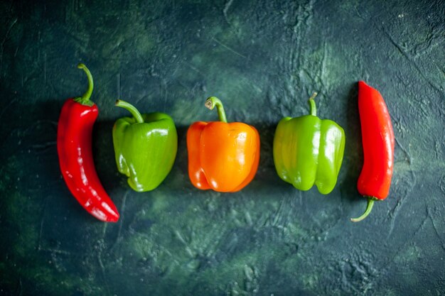 Top view fresh peppers on dark-blue background chilli vegetable sauce color photo food spice