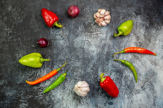 Top view fresh peppers with garlic on light-grey table