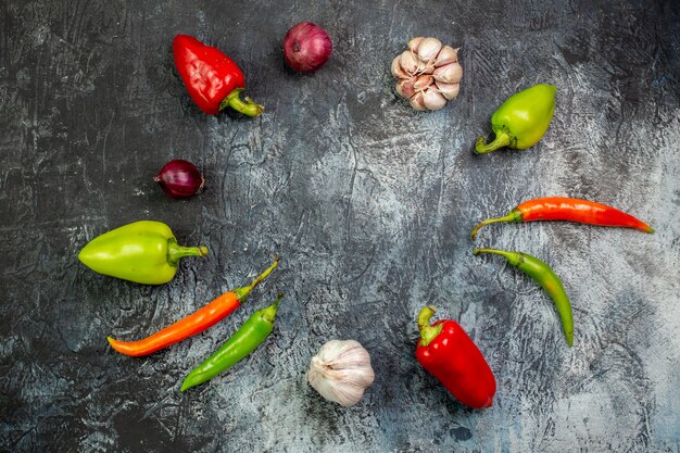 Top view fresh peppers with garlic on light-grey table