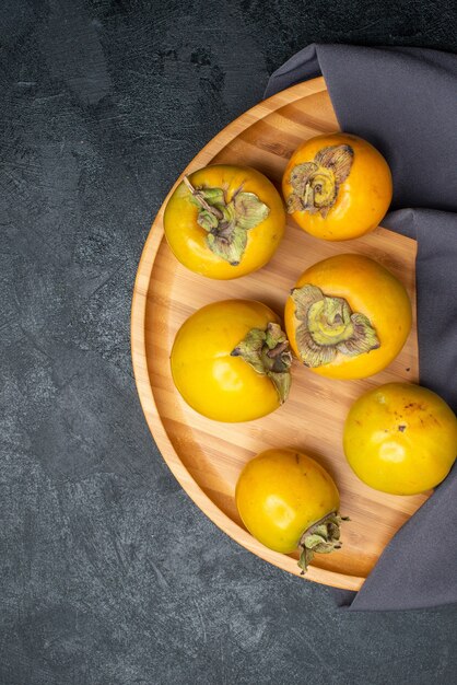 Top view fresh persimmon ripe sweet fruits on dark table, fruit mellow ripe