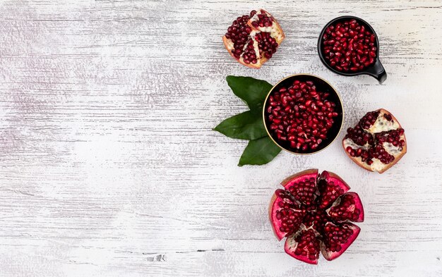 Top view fresh pomegranate seeds with copy space on wooden table